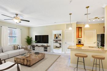A living room with a bar area and a television at The Lofts at Reynolds Village Apartments, North Carolina, 92627